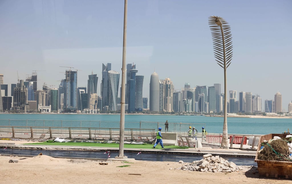 Arbeiter sind auf einer Baustelle an der Promenade Corniche mit Blick auf die Skyline von West Bay Doha zu sehen.