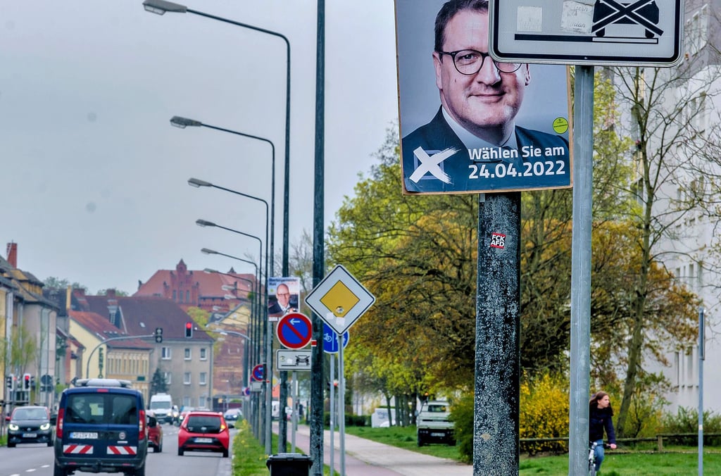 Sie wollen da rein. Torsten Zugehör (vorn) und Herausforderer Dirk Hoffmann (Mitte) auf Plakaten vor dem Hintergrund des Neuen Rathauses