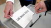 Eine Frau wirft ihren Wahlzettel in eine Wahlurne. Am 24. April 2022 wurde in Magdeburg ein neuer OB gewählt. Es kommt zur Stichwahl.