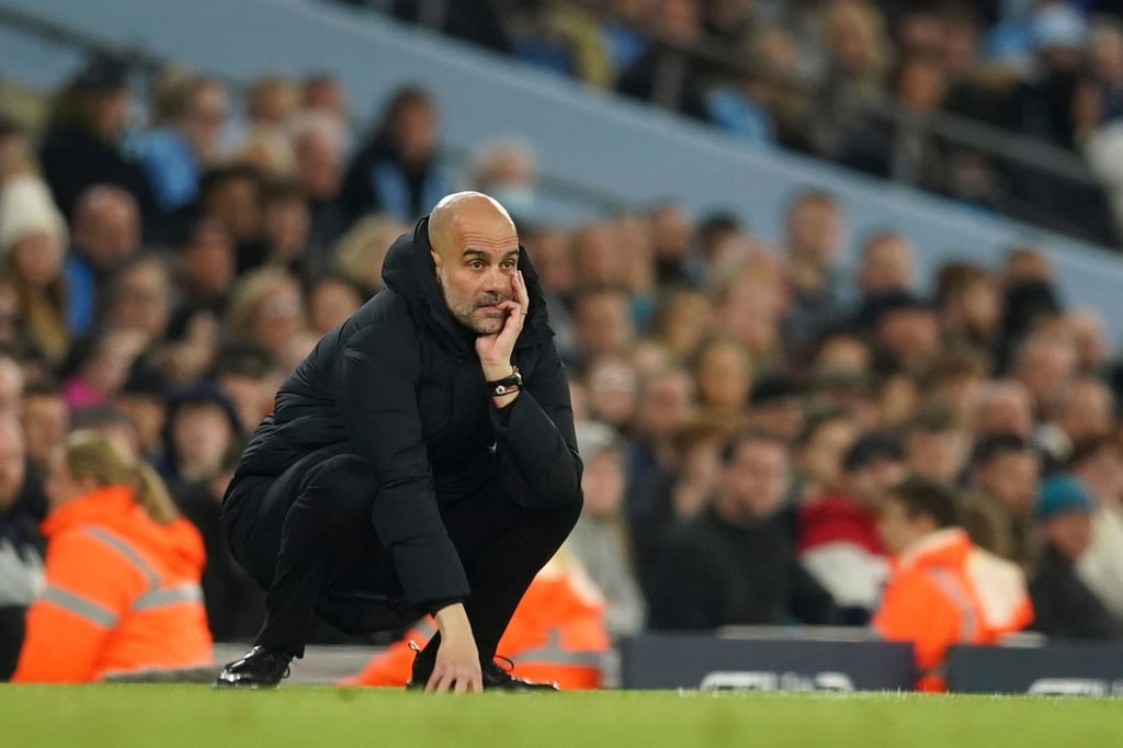 Pep Guardiola, Trainer von Manchester City, hockt an der Seitenlinie und studiert das Spiel seiner Mannschaft.