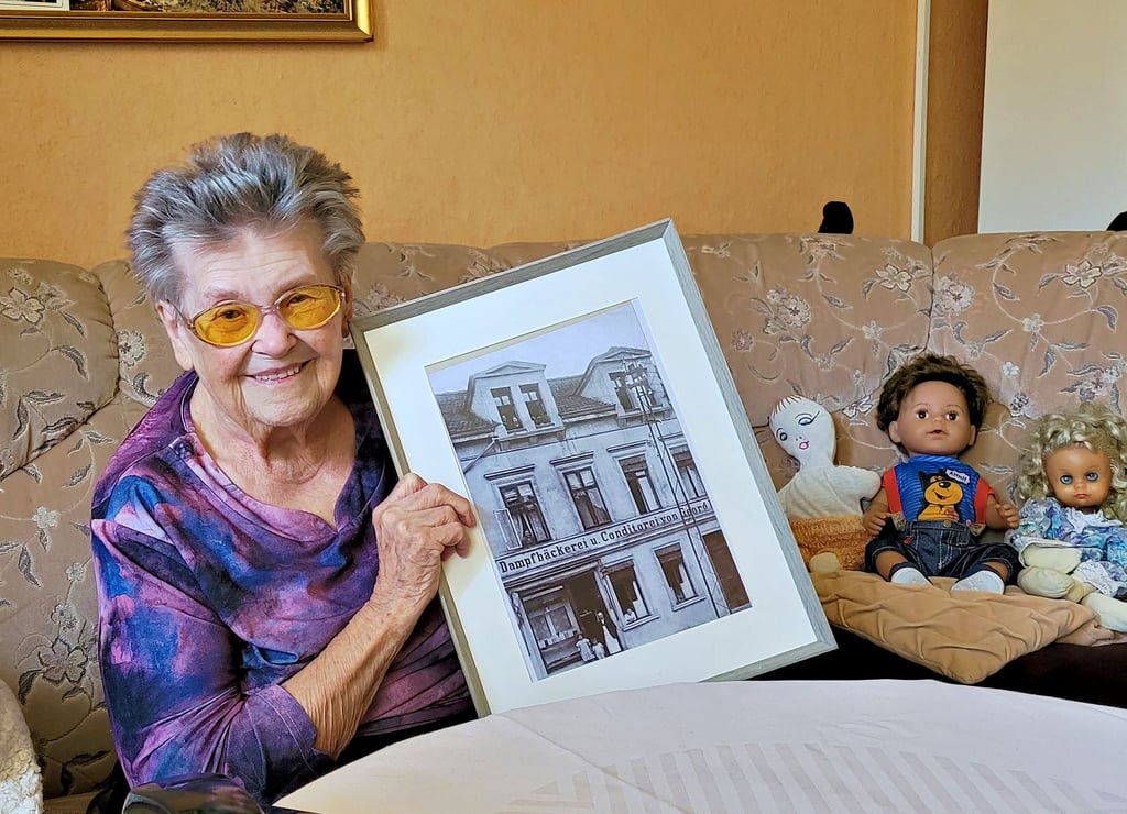 Else Wirth hält das Bild von ihrer damaligen Bäckerei "Wirth" in den Händen. Zusammen mit ihrem Mann leitete sie das Geschäft bis zum Verkauf 1984.
