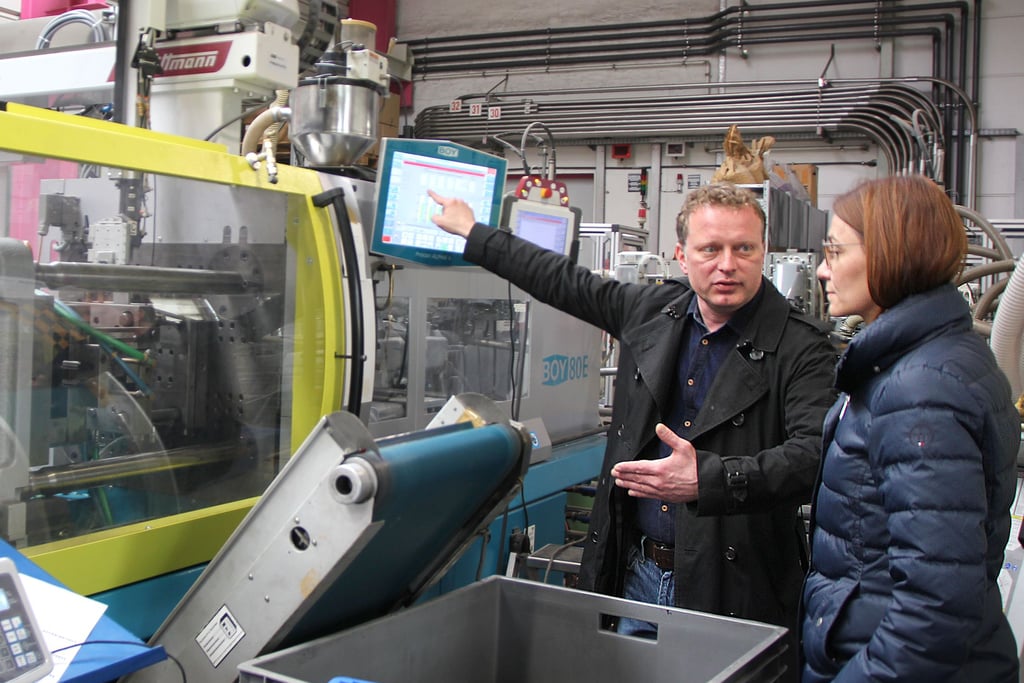 Ohne Energie läuft bei der Firma Reico-Kunststoff-Technik GmbH in Oebisfelde nichts: Erik Möllmann erklärt Sandra Hietel den Energieverbrauch an der Spritzgussmaschine.