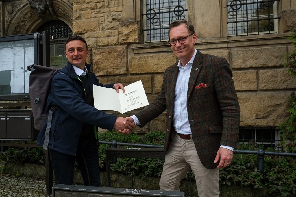 Matthias Marx überreicht Oberbürgermeister Christian Thieme (r.) die Mitgliedsurkunde für die AGFK.