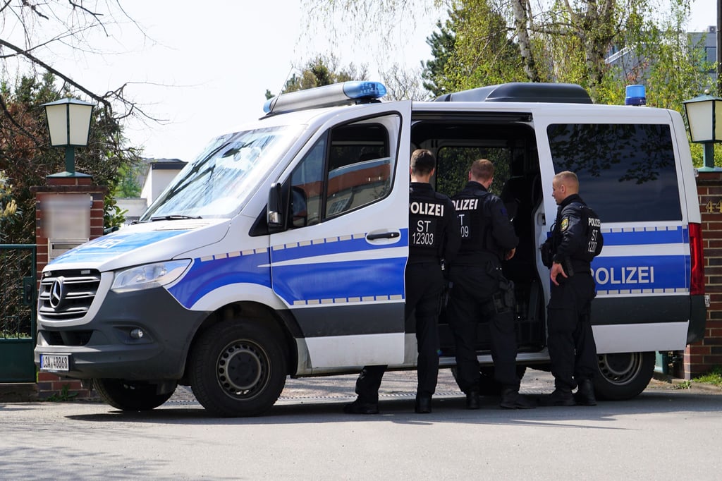 Am Donnerstagvormittag blockiert die Polizei die Zufahrt zu einem Firmengelände in Halle.
