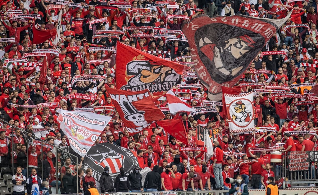 Fans von VfB Stuttgart feuern ihr Team aus dem Gästeblock des Olympiastadions an.