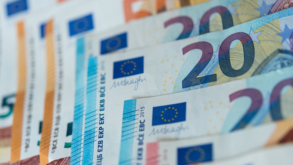 Illustration: Euro-Banknoten liegen sortiert auf einem Tisch. Erwerbstätige sollen einen Einmalbonus in Höhe von 300 Euro erhalten.