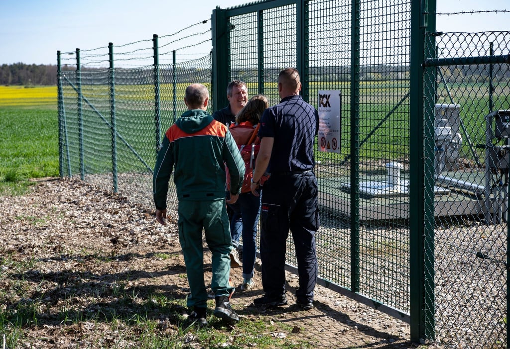 Eine Aktivistin der „Letzten Generation“ wird unweit von Breydin (Brandenburg) von Sicherheitskräften am Betreten einer Betriebsanlage der PCK Raffinerie GmbH gehindert.
