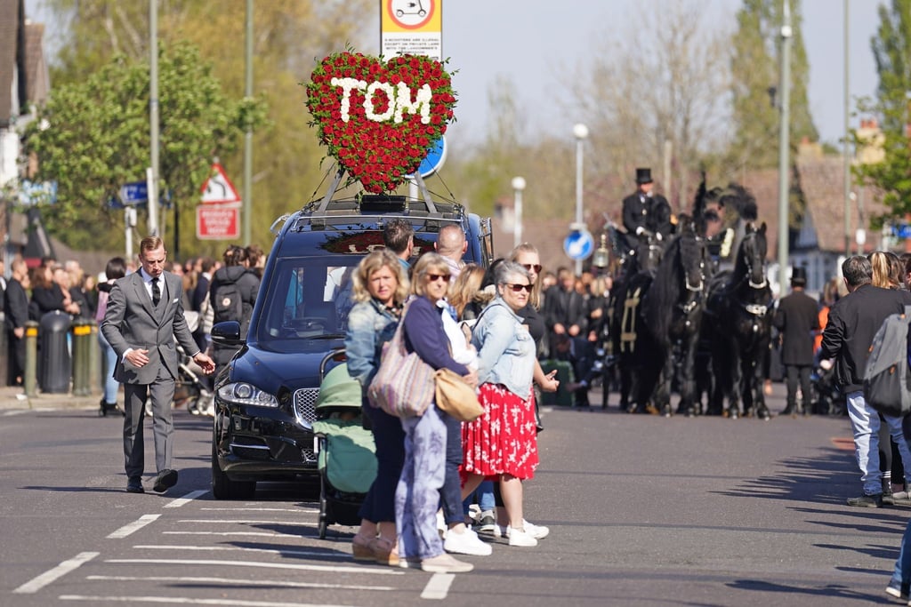 Ein Herz aus Rosen mit der Aufschrift „Tom“ schmückt den Leichenwagen: Viele Menschen nahmen Abschied vom britischen Sänger Tom Parker.