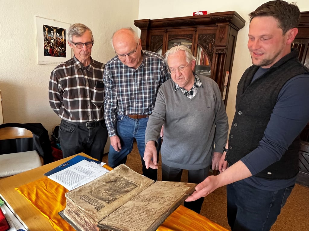 Jürgen Neumann, Hans-Jürgen Gröpke, Martin Kunze und Tobias Gruber betrachten die historsche Bibel.