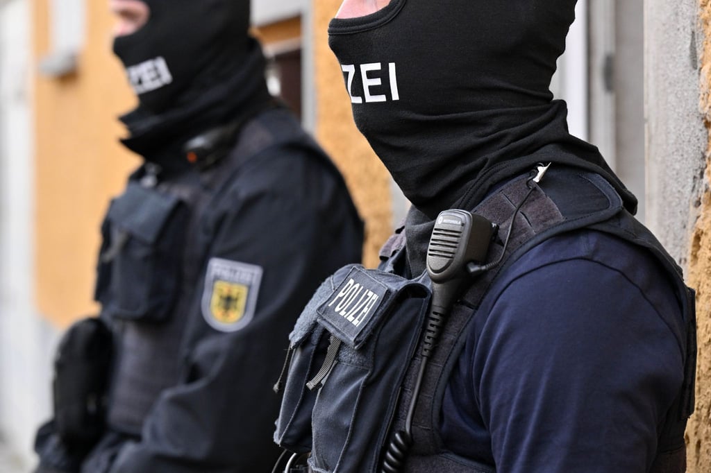 Bundespolizisten stehen vor einem Hauseingang.