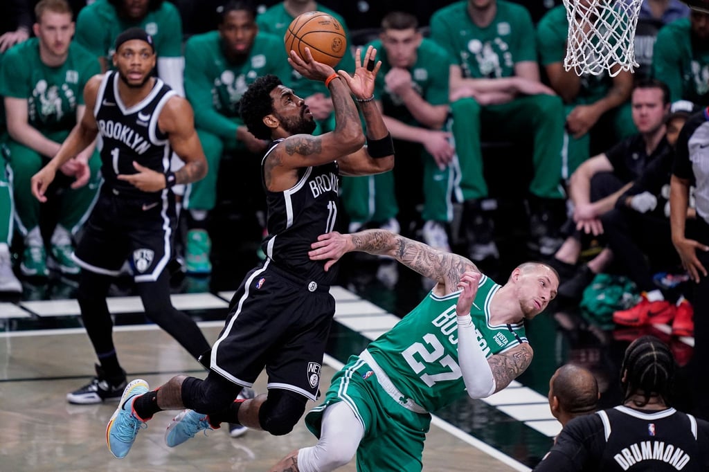 Kyrie Irving (M, l) von Brooklyn foult Daniel Theis (M, r) von Boston.