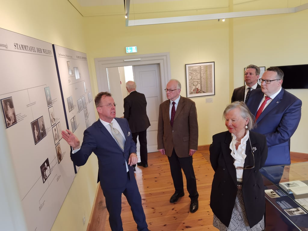 Der Kunsthistoriker Ulrich Feldhahn erläutert den prominenten Gästen die extra für die neue Ausstellung konzipierte Stammtafel der Welfen.