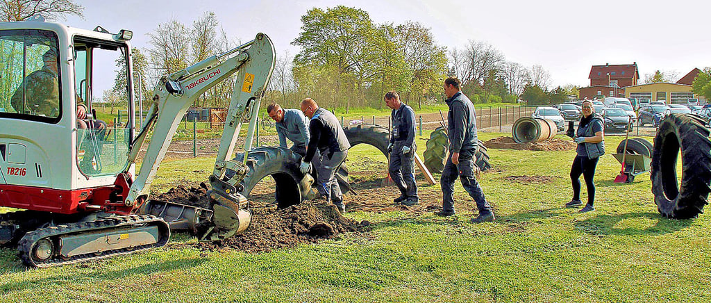 Arbeitseinsatz in Uchtdorf: Aus den großen Reifen soll eine riesige Schlange entstehen, an deren Ende der Tunnel mit Rodelberg lockt.