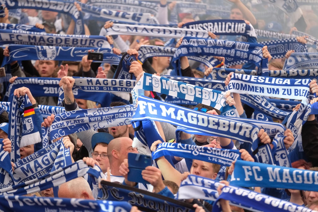Fans des 1. FC Magdeburg jubeln. Nach dem Sieg gegen den FSV Zwickau ist der Club in die zweite Fußball-Bundeliga aufgestiegen.
