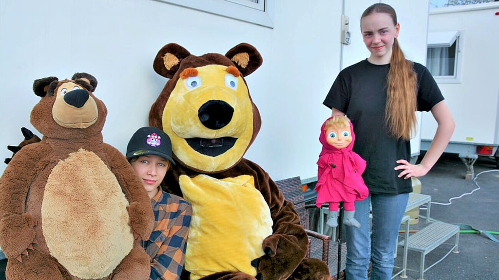 Peter Spindler posiert nach dem Auftritt im Theaterzelt als großer Bär für Fotos. Hier mit seinen Kindern David und Loren, die das Puppenspiel von der Pike auf lernen.