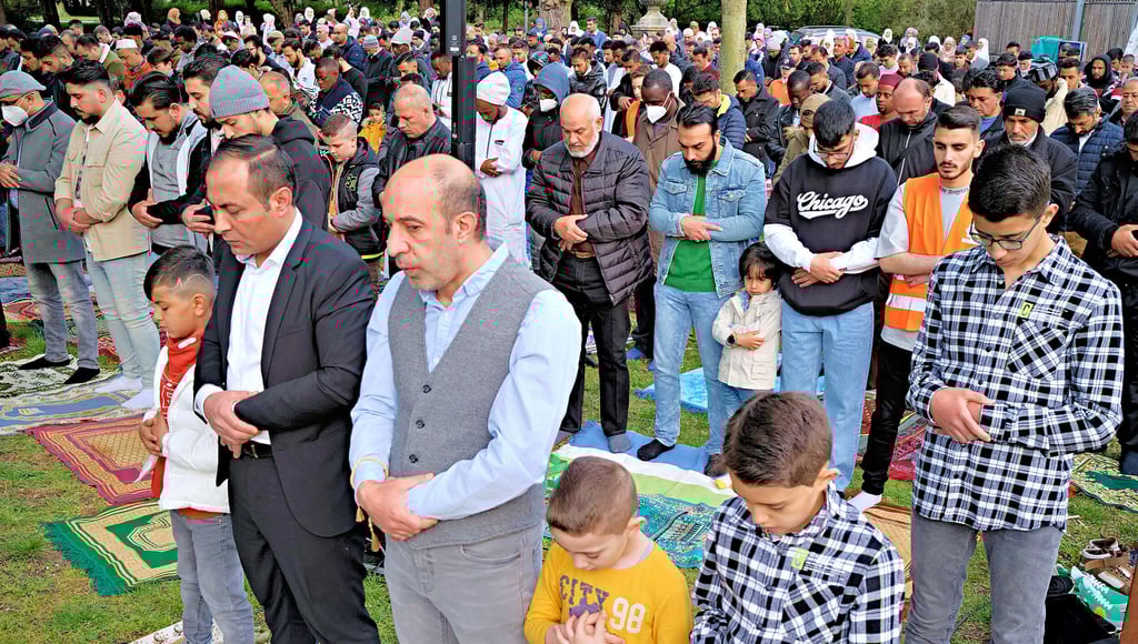 Frauen bleiben während der Predigt im Hintergrund. Männer und Kinder beten gen Mekka.