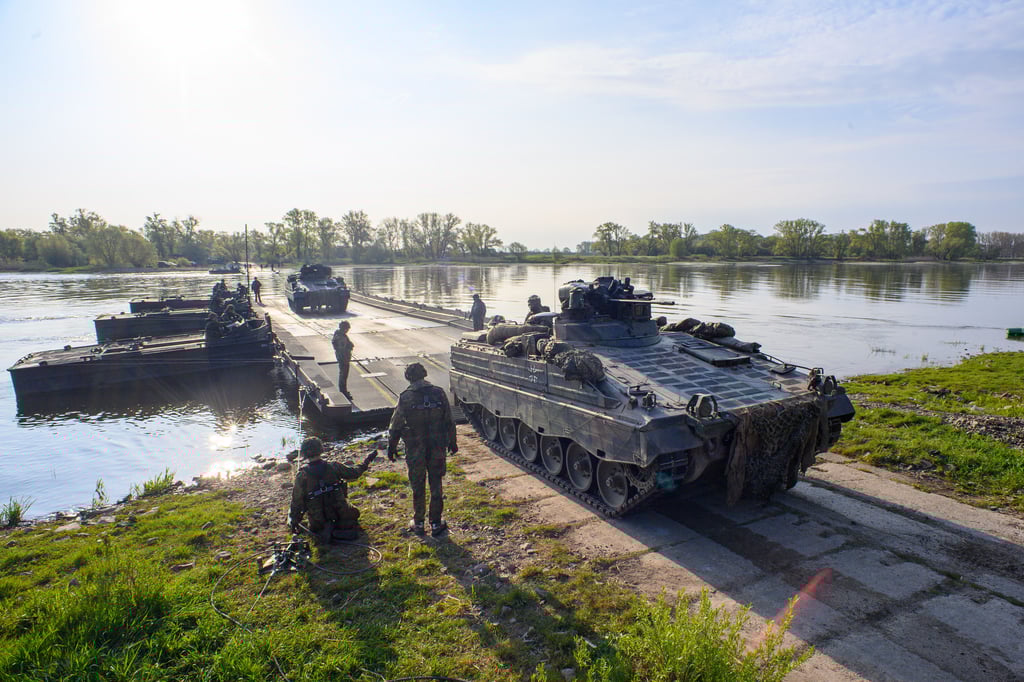 Ein Schützenpanzer "Marder" rollt von einer Schwimmschnellbrücke an Land.
