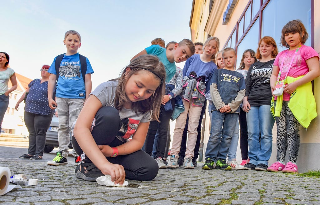 Amelie reinigt einen Stolperstein in Eisleben. Die Mädchen und Jungen von der Freizeiteinrichtung „Zeche“ befassen sich gerade in einem Projekt mit dem Thema Judenverfolgung und Vernichtung im 2. Weltkrieg.