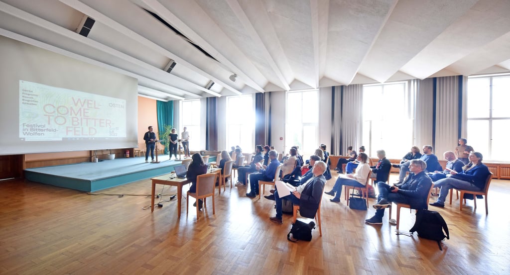 Mit "Welcome to Bitterfeld" eröffnet die Pressekonferenz im Bitterfelder Kulturpalast.