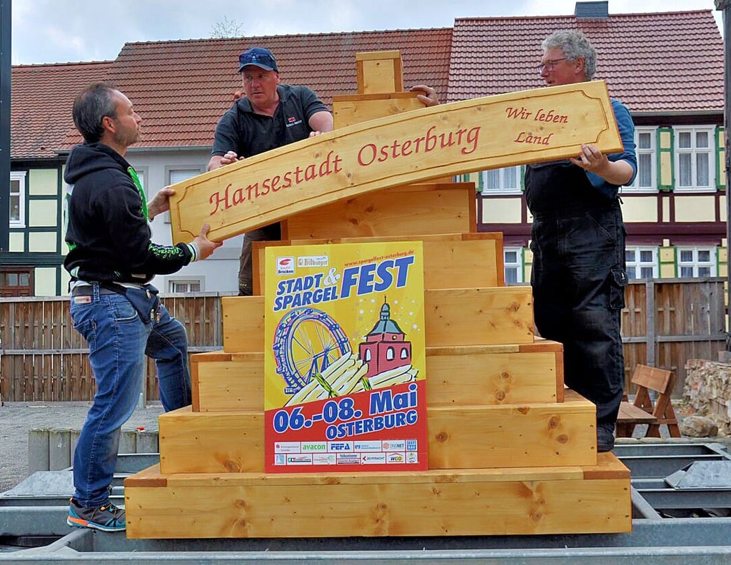Christian Lübeck (links) und Lothar Welte (rechts) mit Guido Lenzner am Osterburger Rathaus beim Aufbau einer Dekoration.