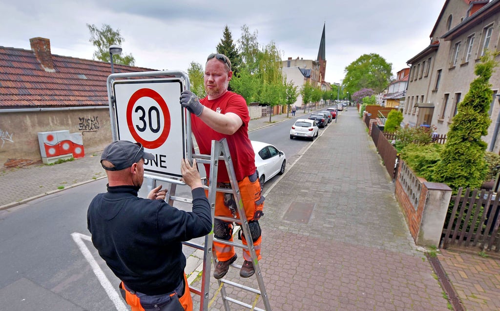 In der Röhrenstraße montieren Mitarbeiter der Firma Verkehrstechnik Hoffmann Schilder für die neue Tempo-30-Zone in der Innenstadt.