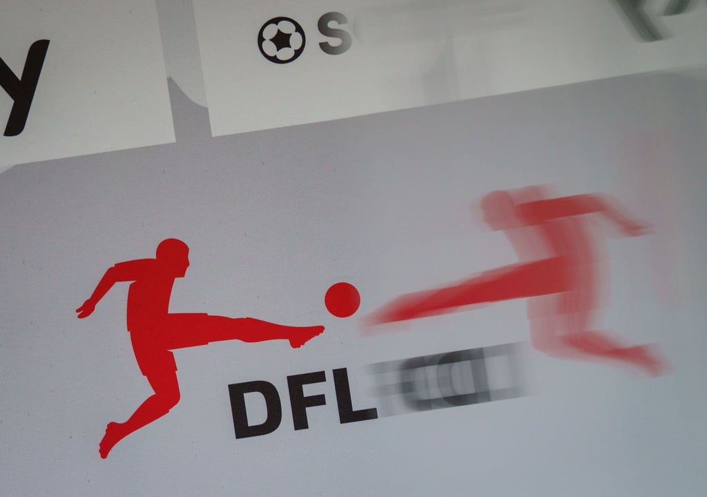 Das Logo der Deutschen Fußball Liga (DFL) spiegelt sich vor Beginn einer Pressekonferenz in einer transparenten Trennscheibe.