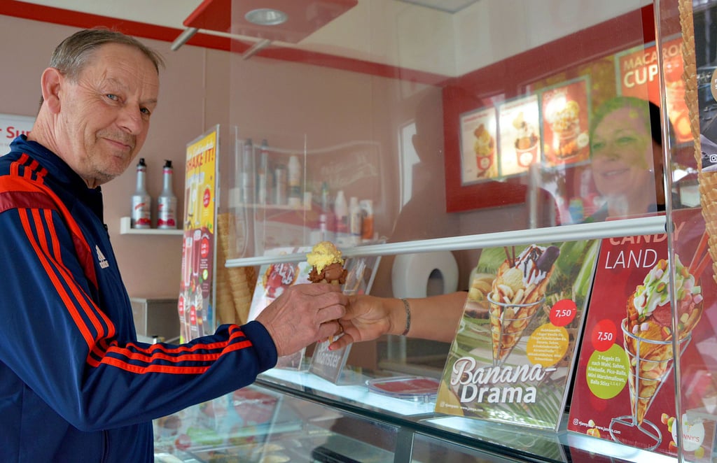 Angela Ising, Geschäftsführerin von „Jannys Eis“ in der Friedrichstraße in Schönebeck, überreicht einem Kunden sein Eis. Wie in anderen Eisdielen und Eis-Cafés in Schönebeck hat auch Ising die Preise angepasst.