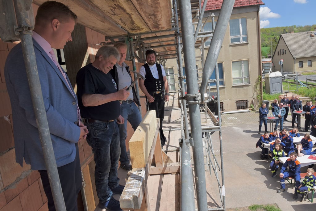 Bürgermeister Carsten Staub, Ortswehrleiter Lothar Kliche, Architekt Günter Hagel und Zimmermann Chris Hofmann (von links) auf dem Gerüst.