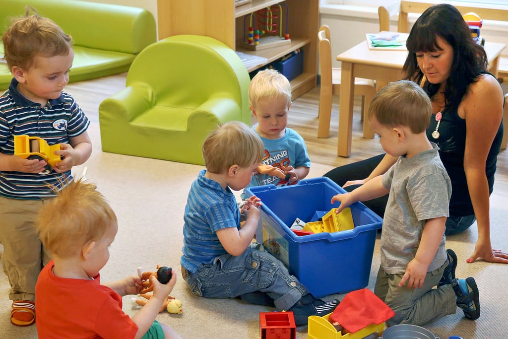 Eine Erzieherin spielt mit Kindern in einer Kindertagesstätte. Der Betreuungsschlüssel kann allerdings nicht immer eingehalten werden.
