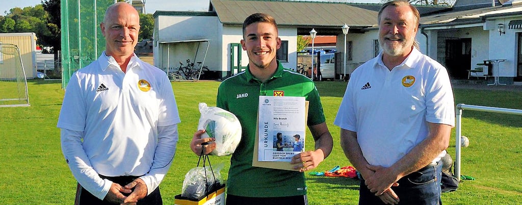 Kleinmühlingens Nils Brandt (M.) bekam von Gerhard Teichert (l.), Geschäftsführer des KFV Fußball Salzland, und Frank Krella, Präsident des KFV Fußball Salzland und Ausschussvorsitzender Freizeit- und Breitensport des FSA, seine Urkunde und Präsente.