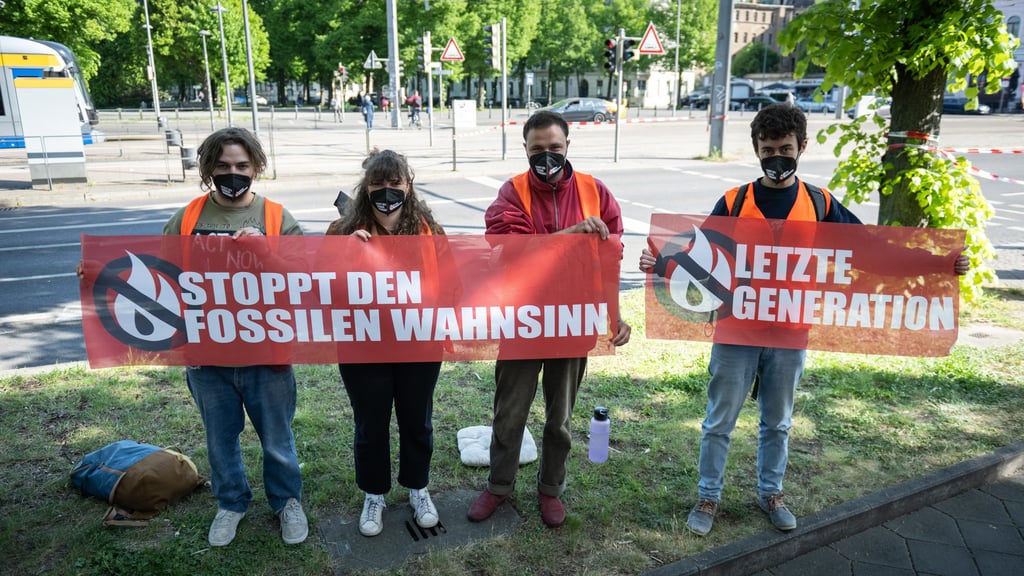 Umweltaktivisten der Gruppe "Letzte Generation" stehen an einer Straße, nachdem sie am Morgen den Berufsverkehr auf der Jahnallee blockierten.