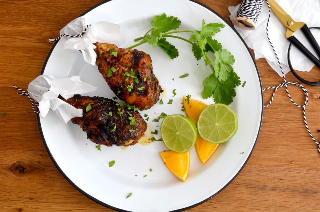 Mit Koriander garniert müssen nur noch die Zitrusfrüchte über dem Fleisch des Jerk Chicken ausgedrückt werden. Das verpasst den Keulen einen extra Frischekick.