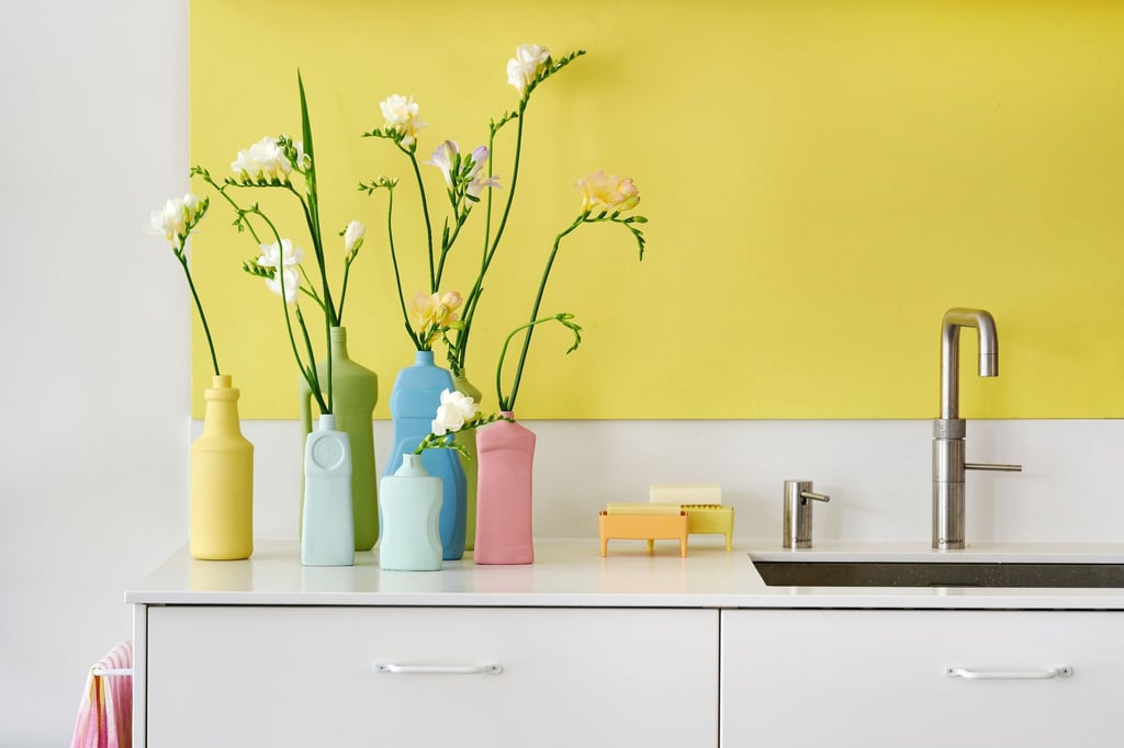 Matte Pastellfarben machen alte Plastikflaschen zu ausgefallenen Vasen für einzelne Blumen.