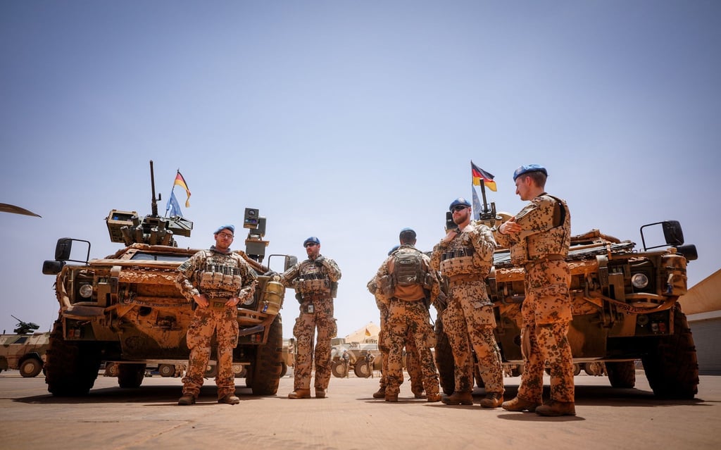 Bundeswehrsoldaten stehen in Gao in Mali im Feldlager Camp Castor an ihren Fahrzeugen.