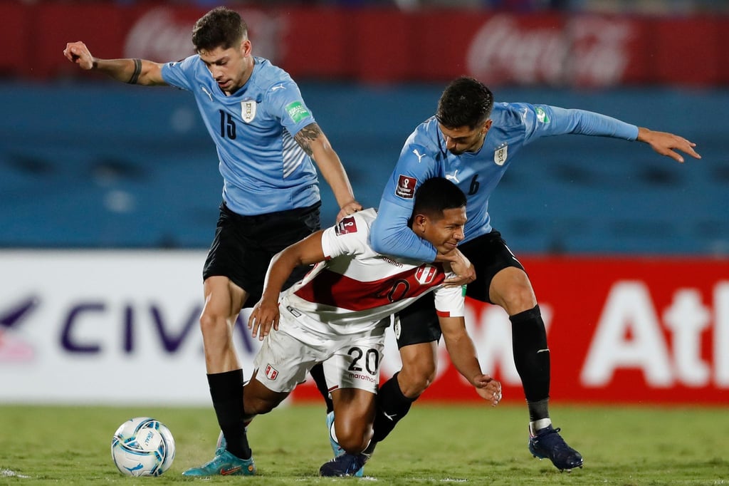 Perus Edison Flores (M) kämpft mit Uruguays Rodrigo Bentancur (r) und Federico Valverde um den Ball.