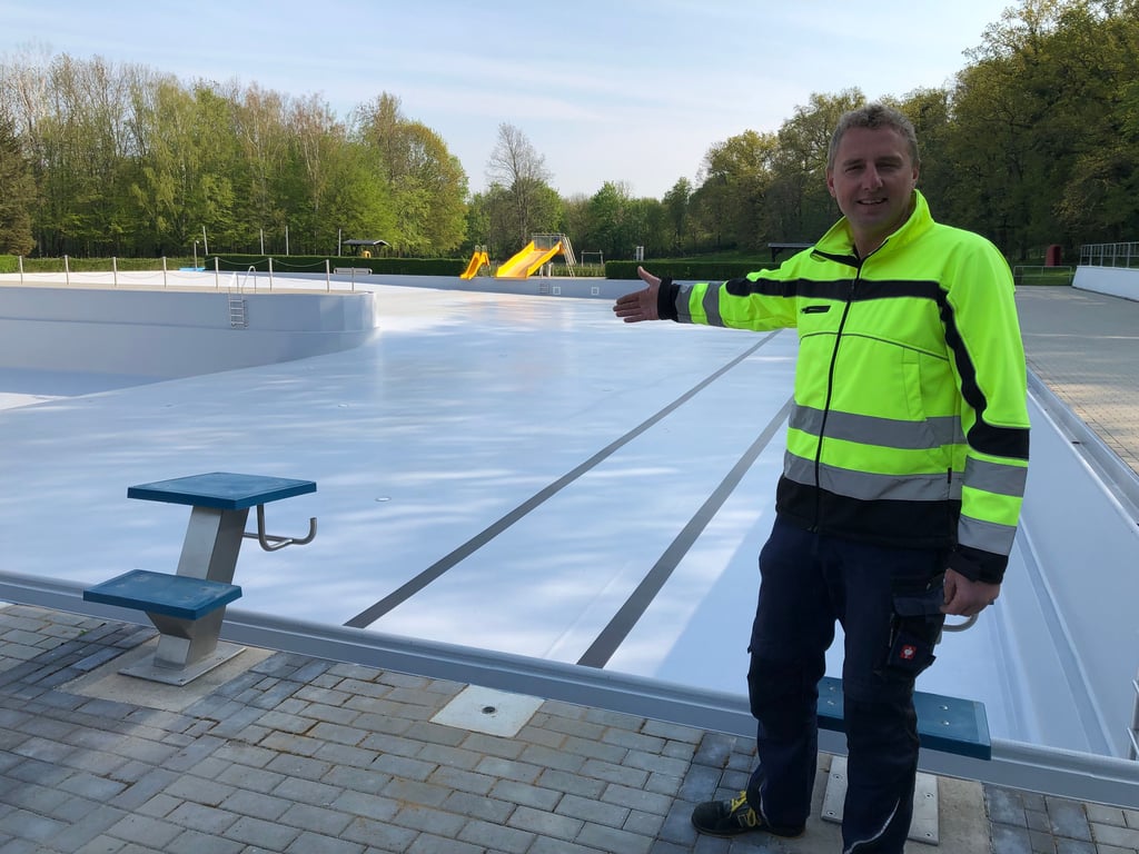 Schwimmmeister Christian Buschhardt zeigt auf das sanierte Schwimmbecken.
