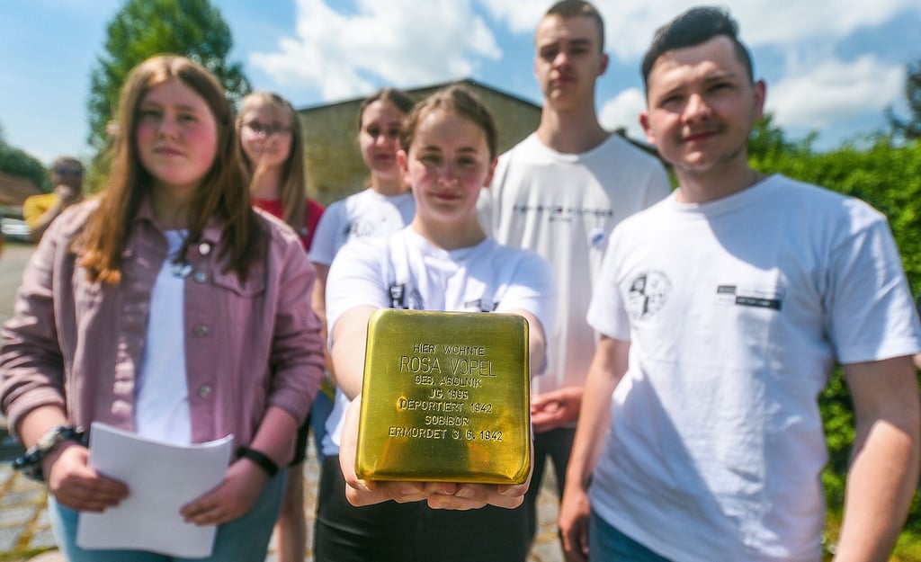 Querfurter Schülerinnen und Schüler zeigen den neuen Stolperstein für Rosa Vopel.