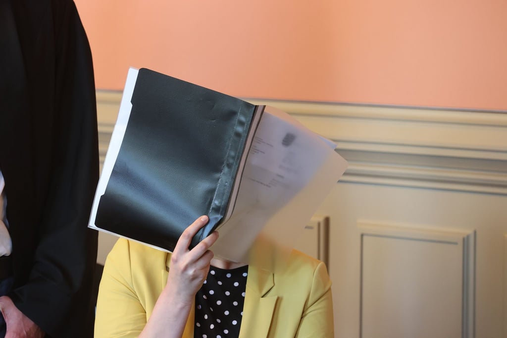 Die Angeklagte sitzt im Verhandlungssaal. Sie wird beschuldigt, ihre Oma ermordet zu haben.