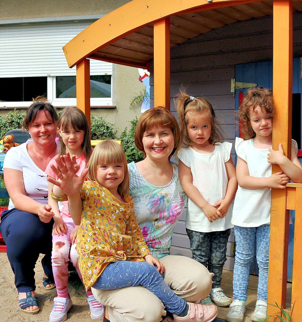 Kitaleiterin Nicole Scheumann (links) und Oxsana Kutschai (Mitte) spielen mit den ukrainischen Kindern im Garten.