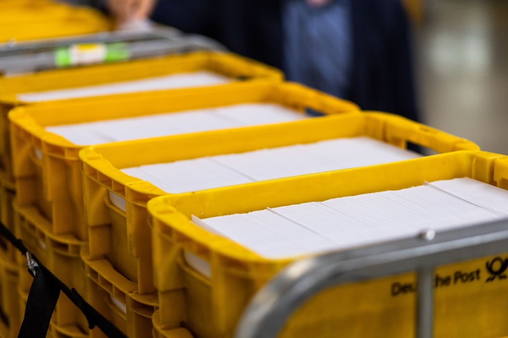 Sendungen des Zensus 2022 liegen im Briefzentrum Offenburg der Deutschen Post in Logistikbehältern.