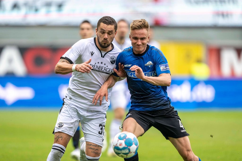 Pascal Testroet (l) vom SV Sandhausen und Paderborns Jasper van der Werff im Zweikampf.