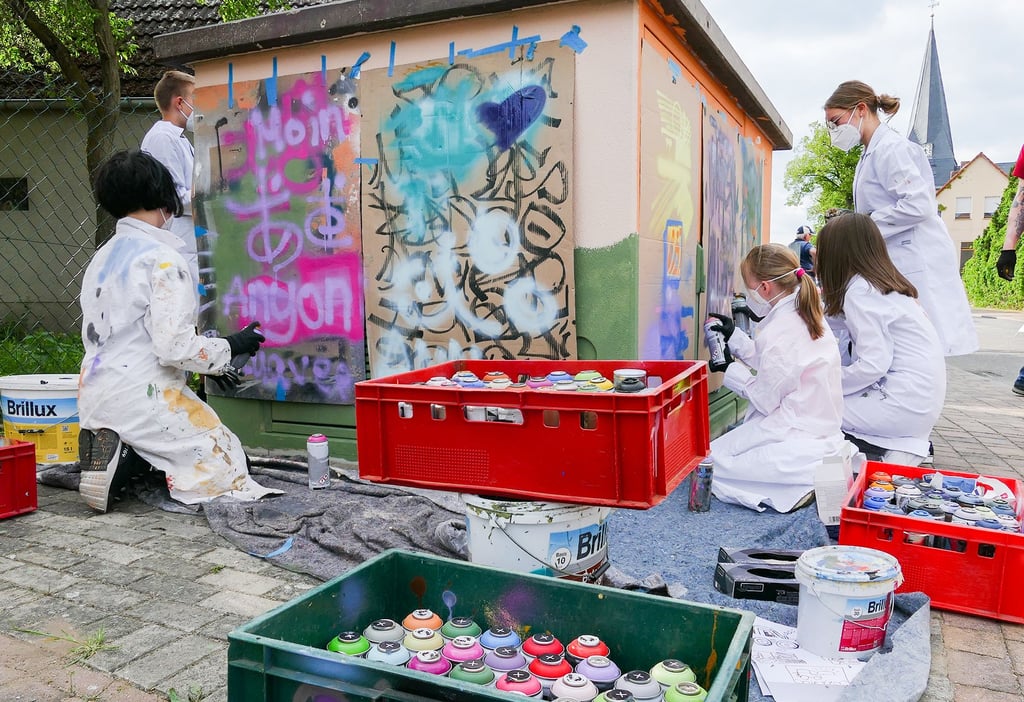 Bevor es an die Wand geht, wird auf Pappe geübt. Die Bethauer Kinder machen aus einem schlichten Stromkasten ein buntes Graffitikunstwerk.