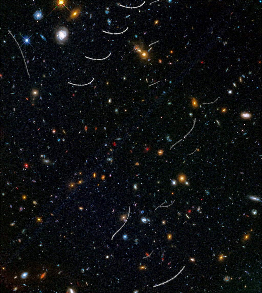 Für das Bild wurden Aufnahmen des Weltraumteleskops Hubble übereinander gelegt. Es zeigt die Bahnen mehrerer Asteroiden (weiße Linien).