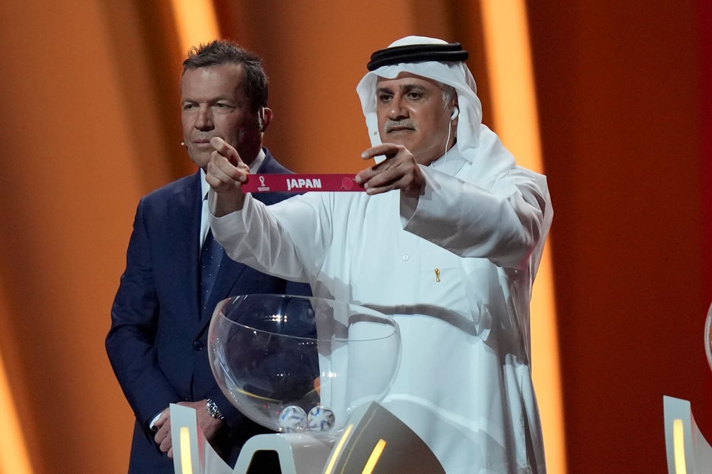 Der ehemalige katarische Fußballnationalspieler Adel Ahmed MalAllah hält das Los mit dem Teilnehmer Japan in der Hand.