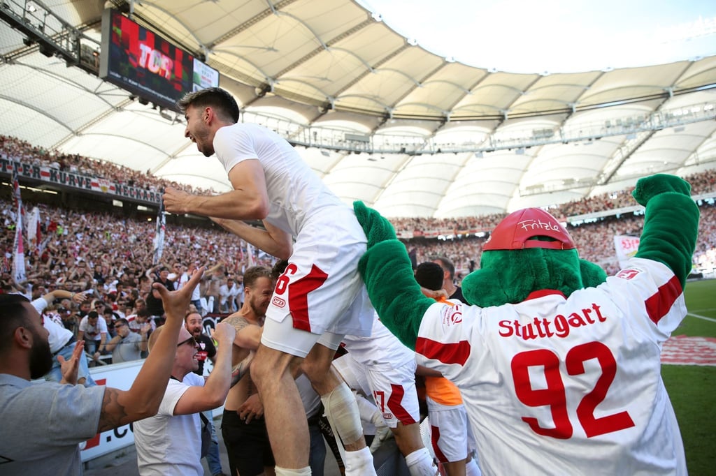 Der Stuttgarter Atakan Karazor (l) feiert mit den Fans das späte Tor zum 2:1 durch Endo.