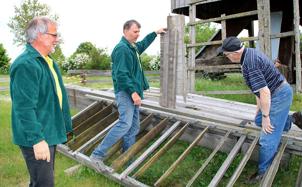 Die Mühlenvereinsmitglieder Dieter Hübsch, Friedhelm Sienholz und Heinz Schüler am abgerissenen Klappenflügel der Bockwindmühle bei Lindhorst.