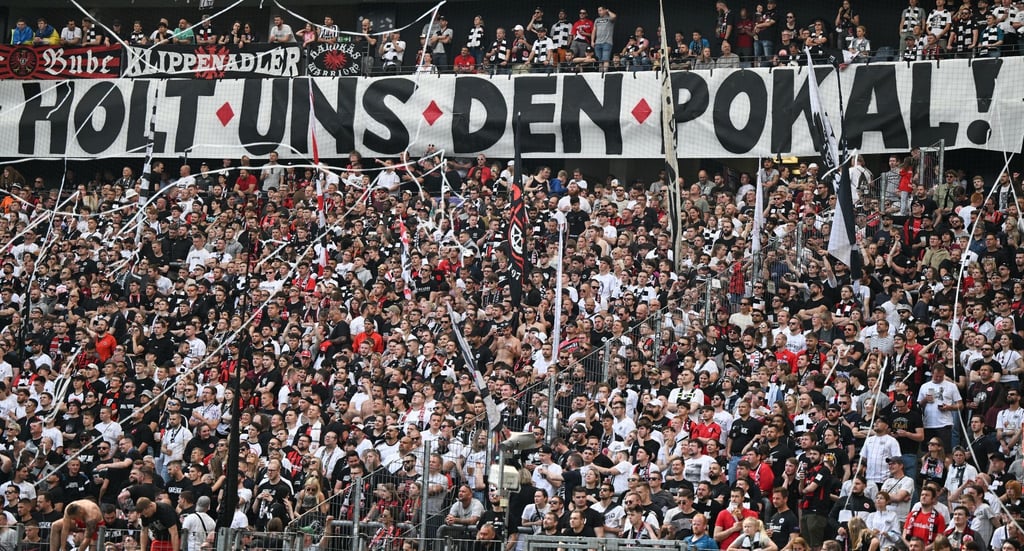 „Holt uns den Pokal!“ steht auf einem Plakat im Frankfurter Fanblock.