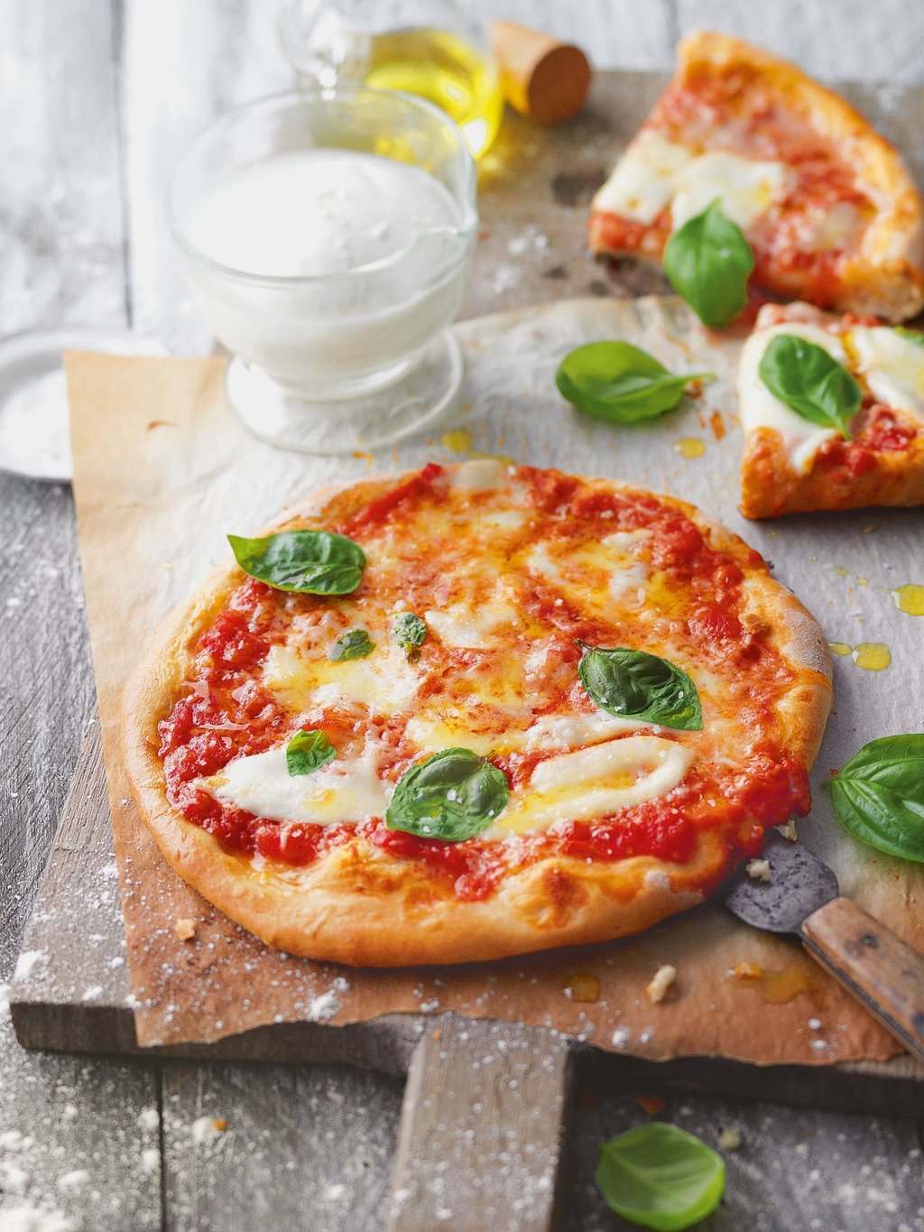 Die Pizza Margherita mit Basilikum, Mozzarella und Parmesan kommt nicht ohne Tomatensauce. Dafür am besten stückige Tomaten aus der Dose nehmen und mit Salz, Pfeffer, einer Prise Zucker und bei Bedarf mit etwas Oregano und frischem Knoblauch abschmecken.