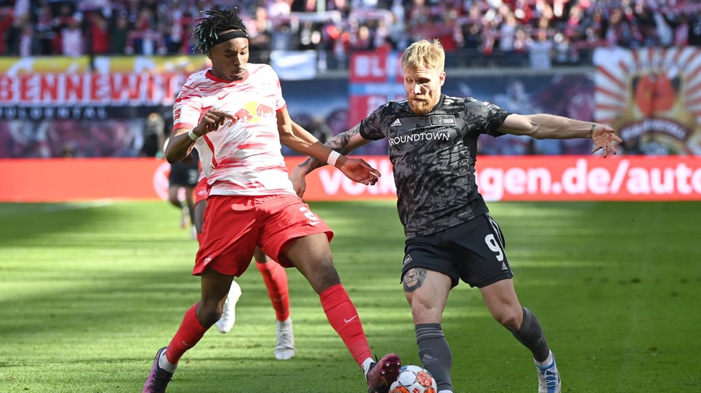 Mohamed Simakan von RB Leipzig (l.) attackiert einen Gegenspieler.