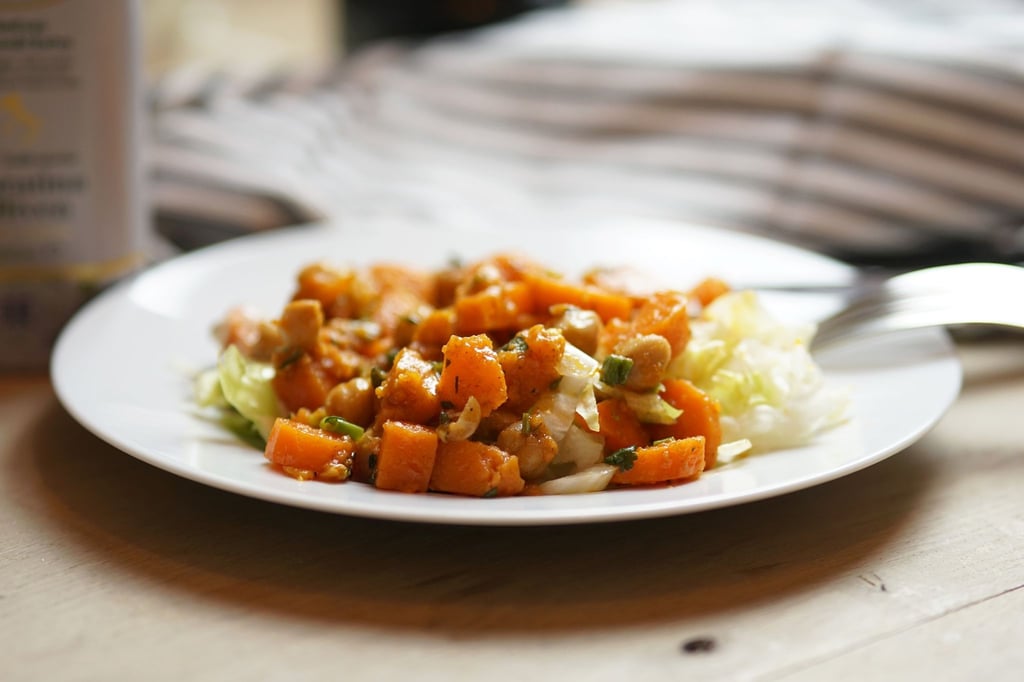 Der herzhafte Salat aus Süßkartoffeln, Kichererbsen und Möhren wird auf Eisbergsalat angerichtet.